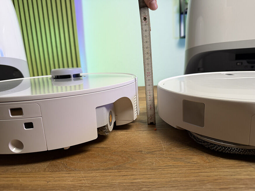 Der Roborock Curv 2 Pro fährt mit eingefahrenem Laserturm unter ein sehr flaches Sofa.